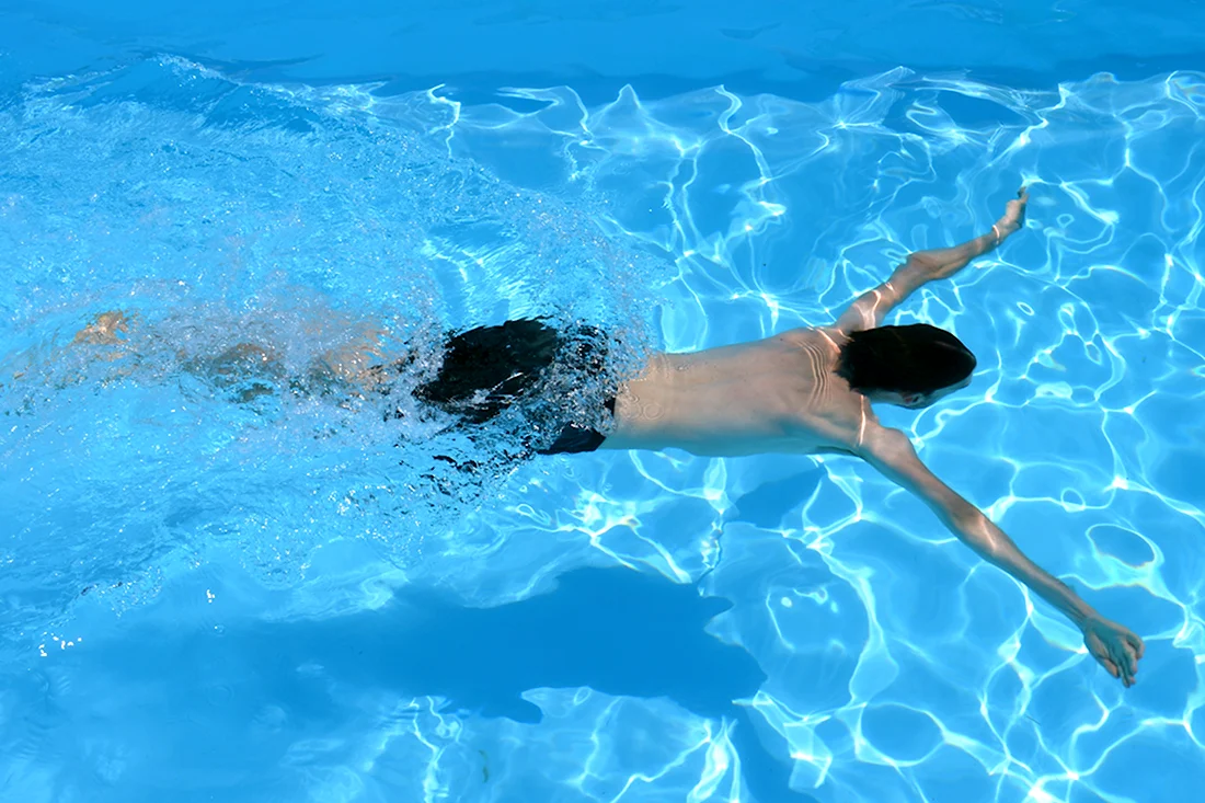 Человек плывет в бассейне